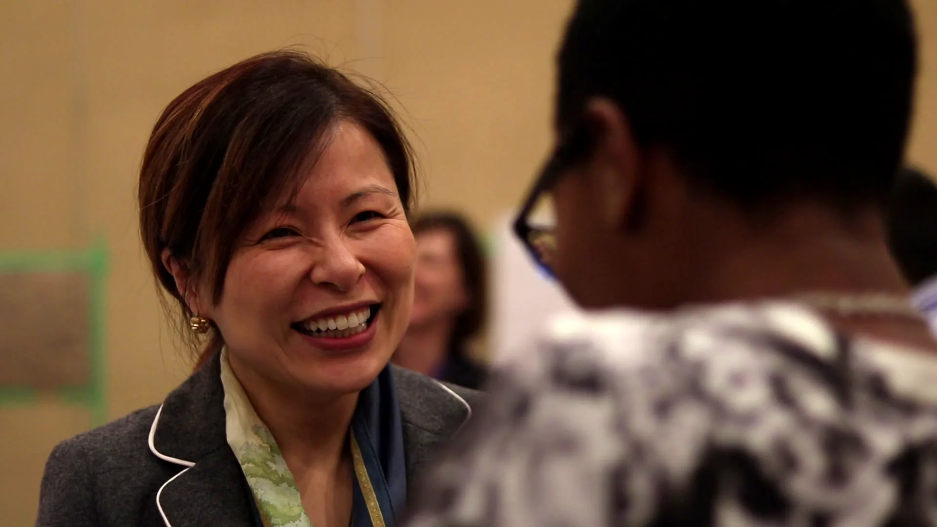A participant beams during a practice conversation at a Naturally experience